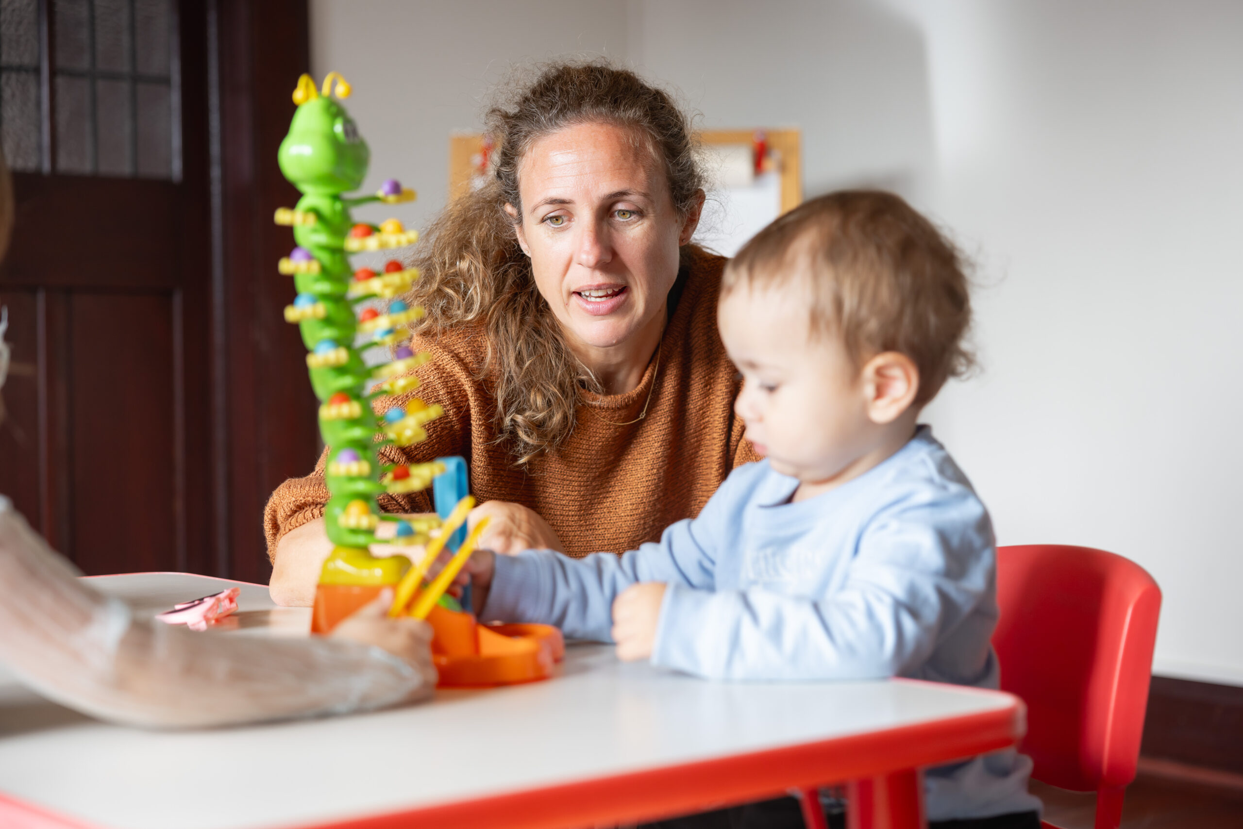 Health professional interacting with game and young child